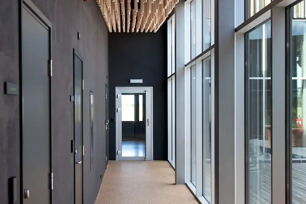 Pasillo de oficina reformado en Oviedo con falso techo acústico de madera